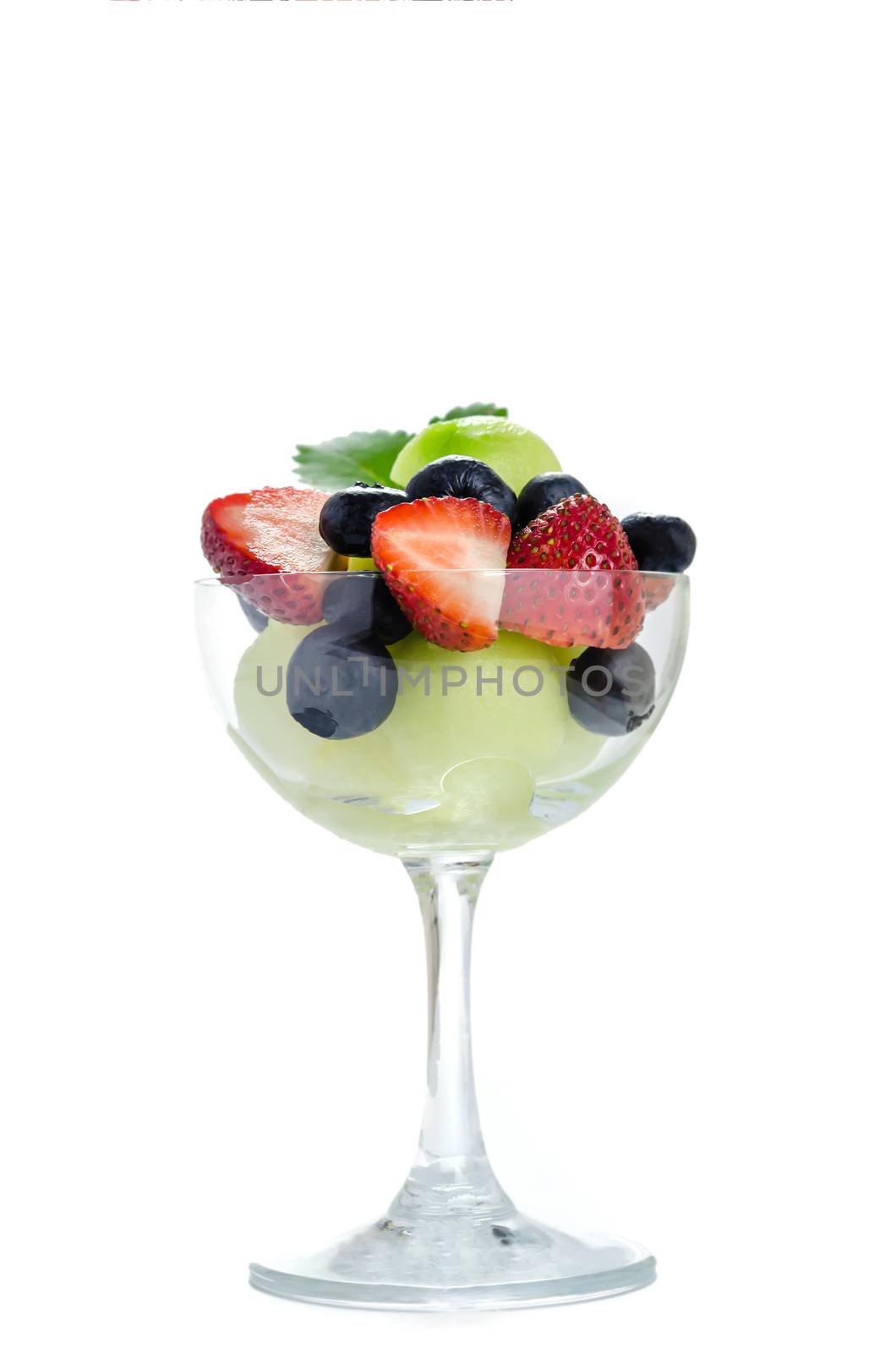 Fresh forest berries and melon in a glass on a white background