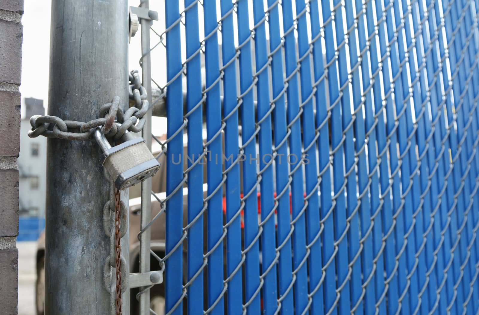 Heavy-duty padlock and chain locking security gate made of metal chainlink and blue plastic