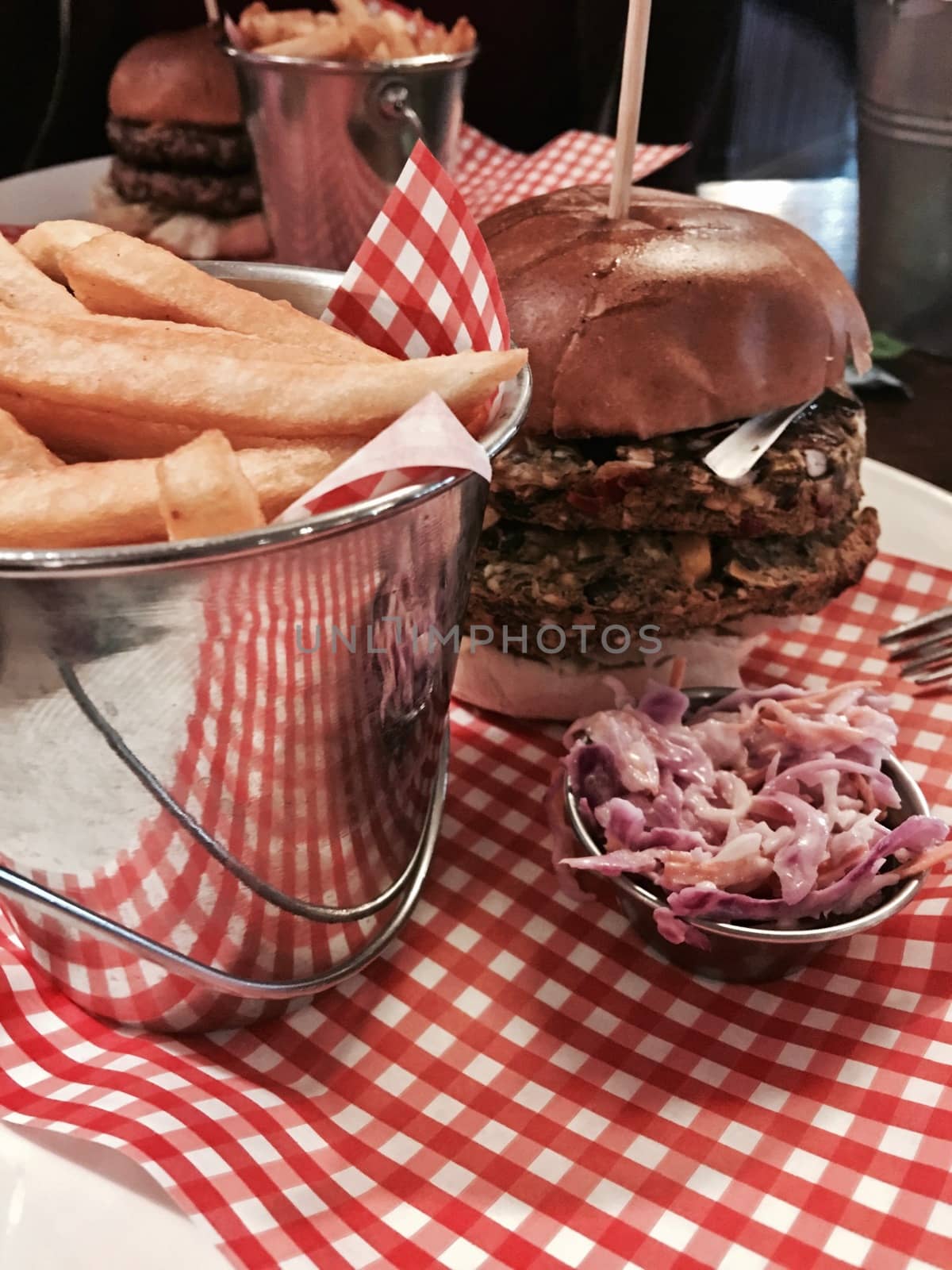Big, fresh and delicious vegetable burger in restaurant on the white plate.