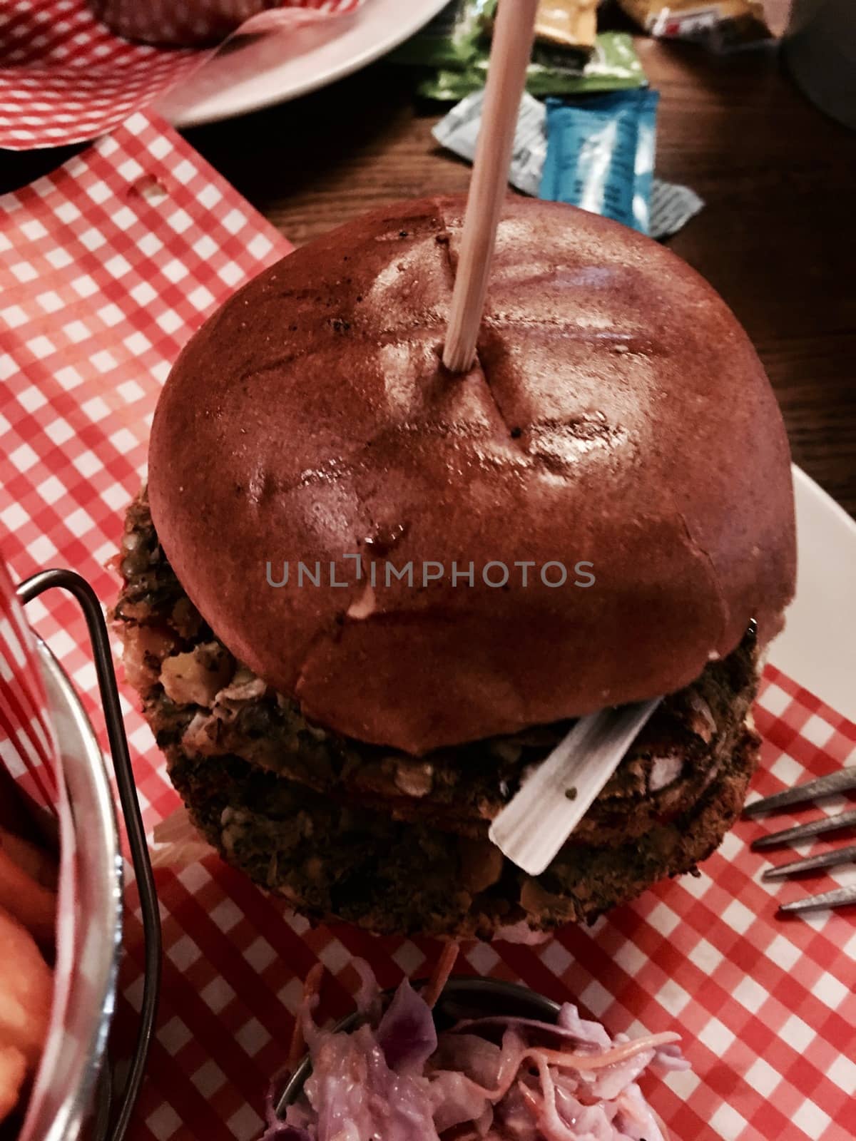 Big, fresh and delicious vegetable burger in restaurant on the white plate.