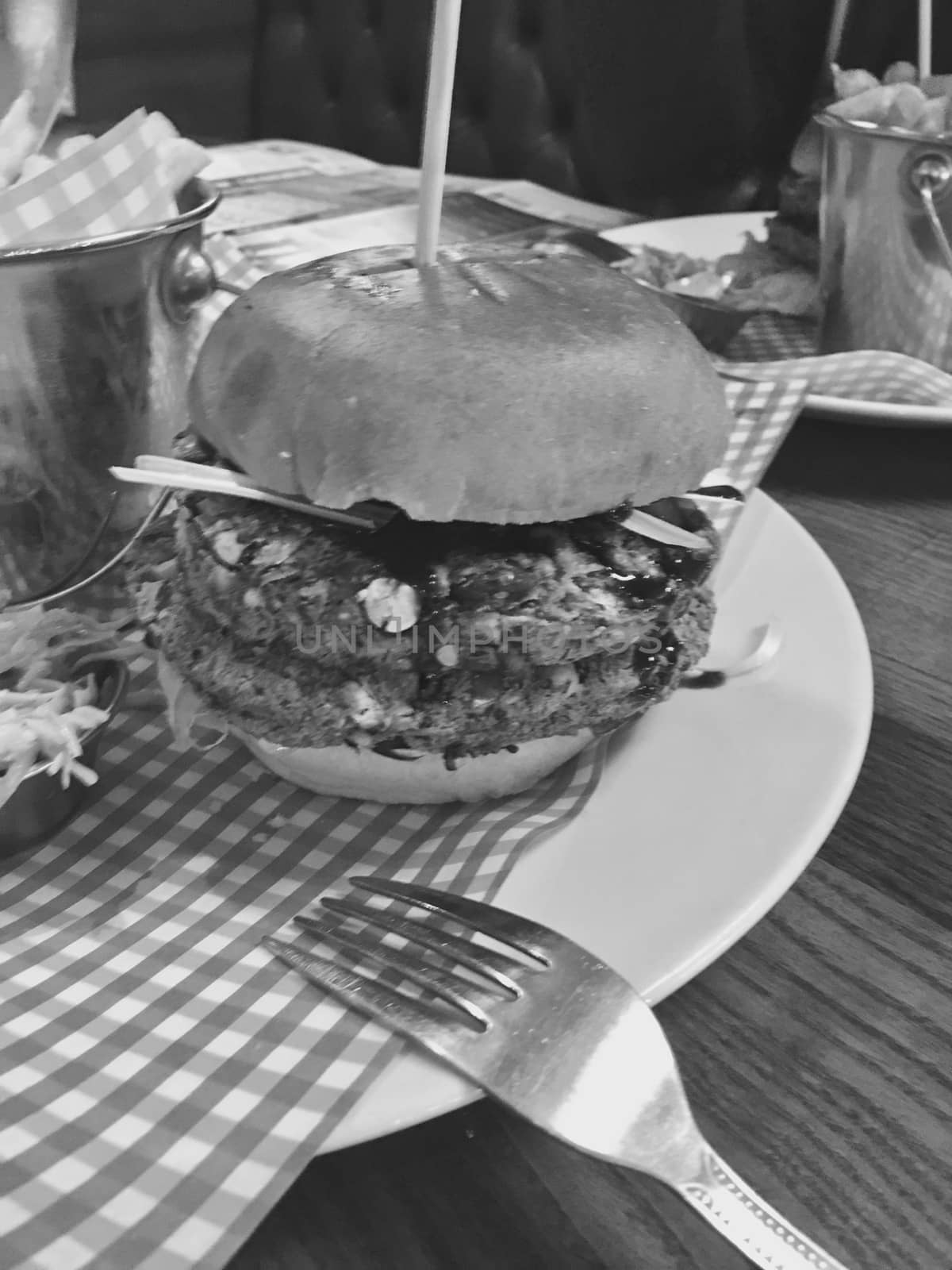 Big, fresh and delicious vegetable burger in restaurant on the white plate.