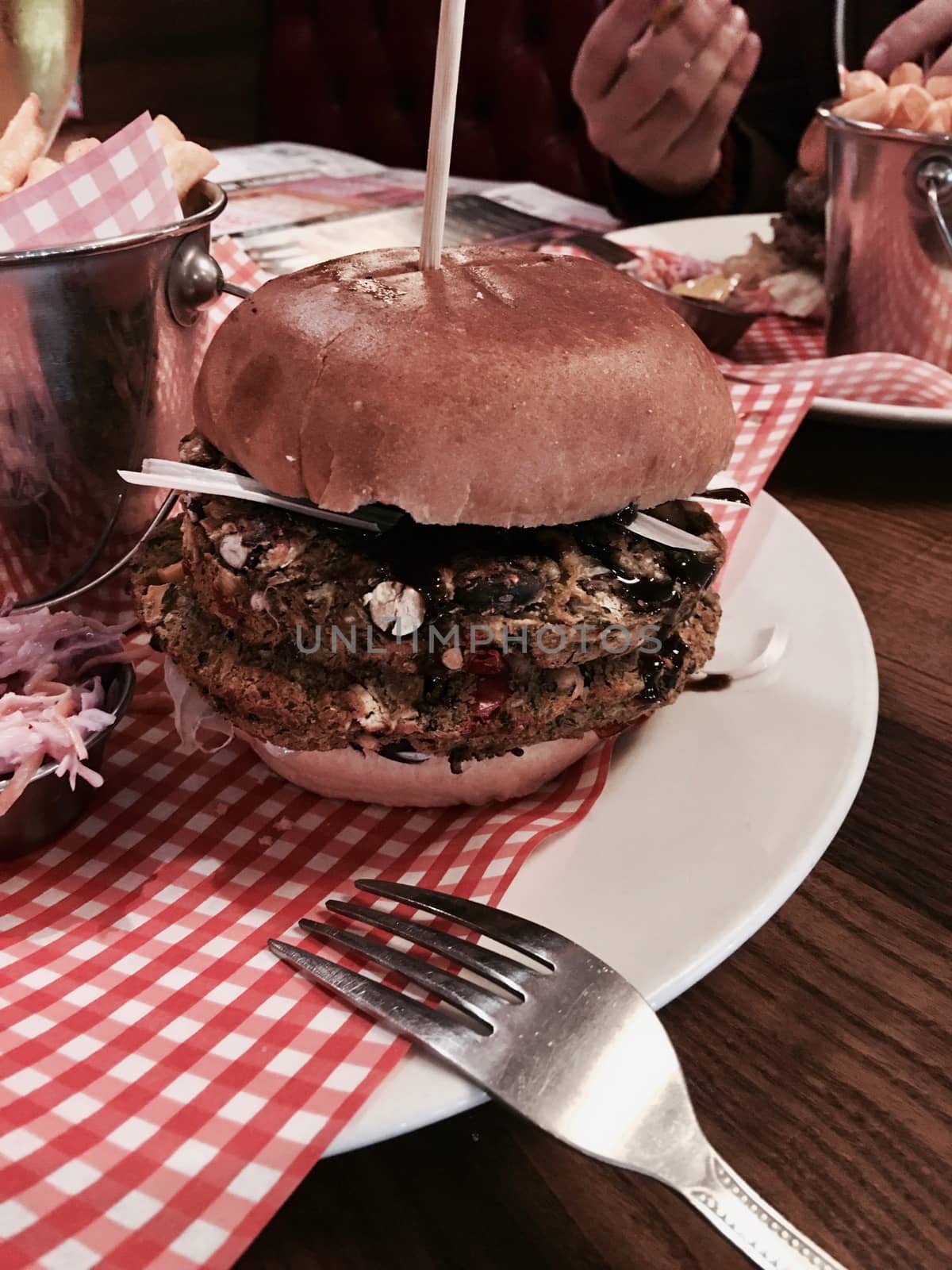 Big, fresh and delicious vegetable burger in restaurant on the white plate.
