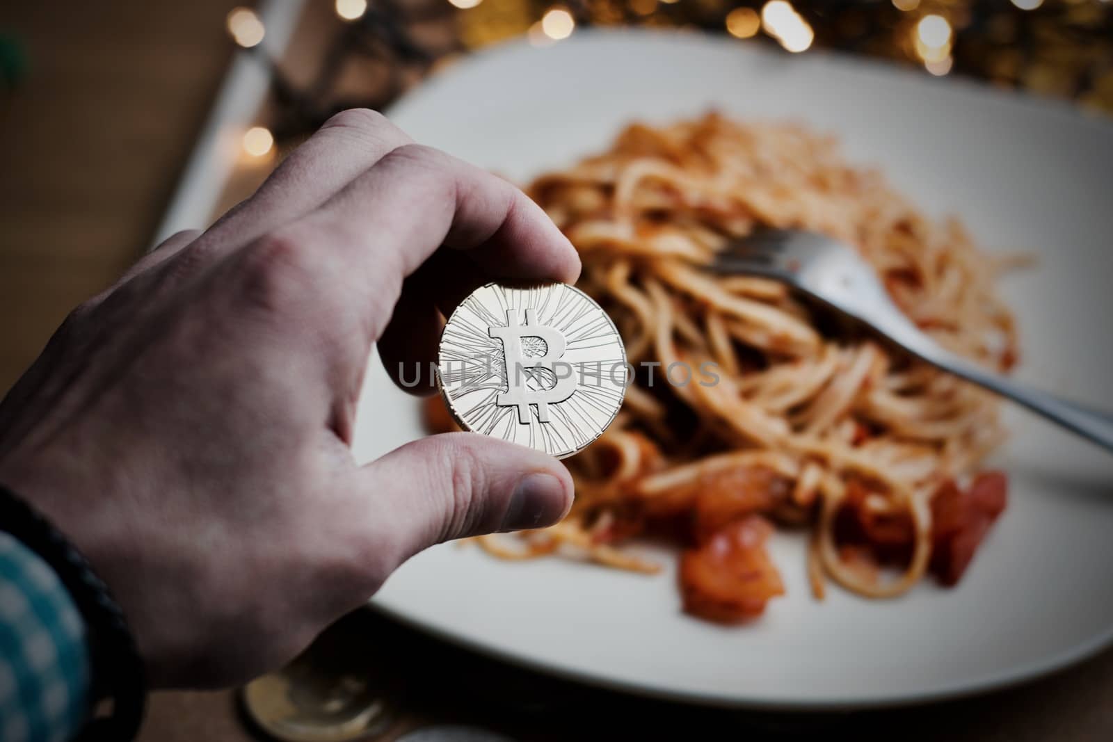 Digital currency physical metal bitcoin coin. Restaurant pasta concept.