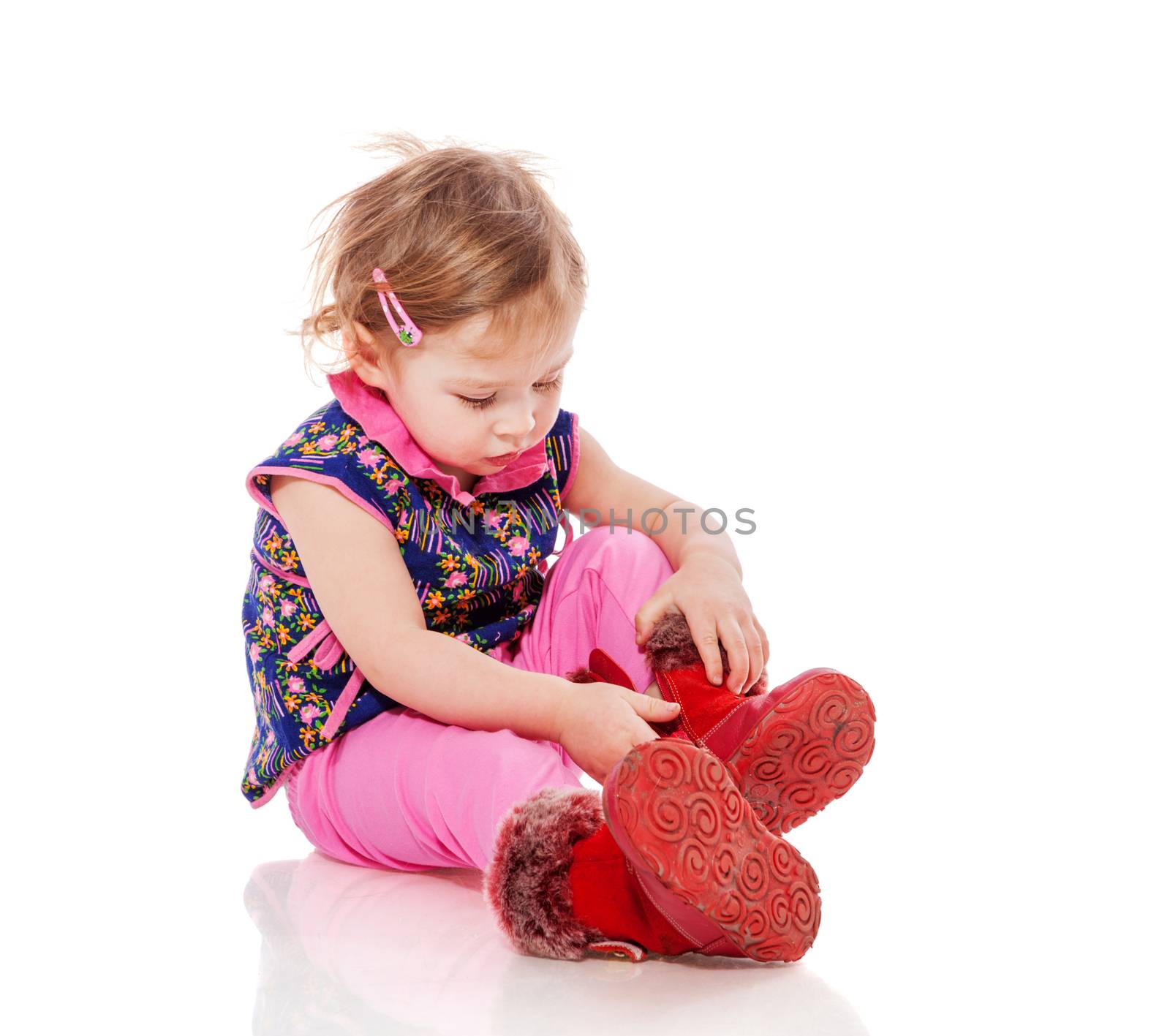 Baby putting on shoes sitting  isolated on white
