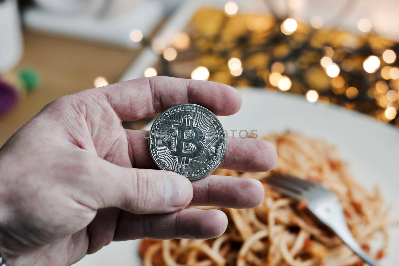 Digital currency physical metal bitcoin coin. Restaurant pasta concept.