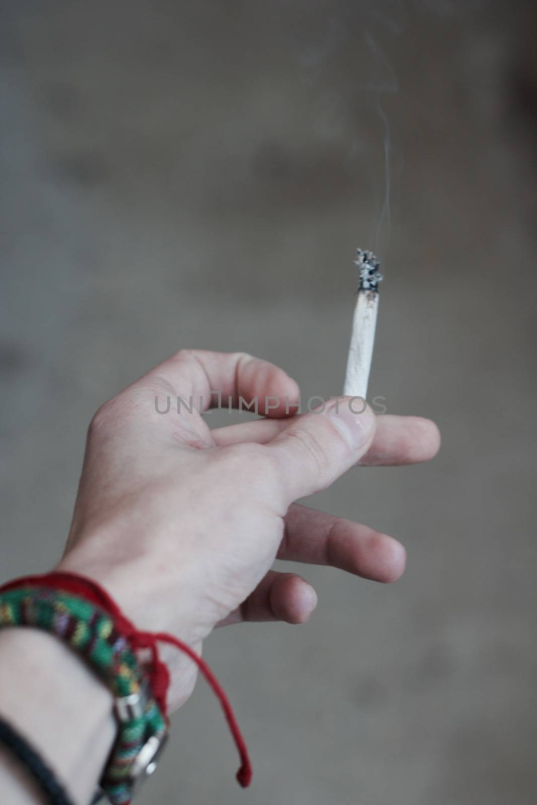 Small spliff in man hand. Marijuana smoking concept.