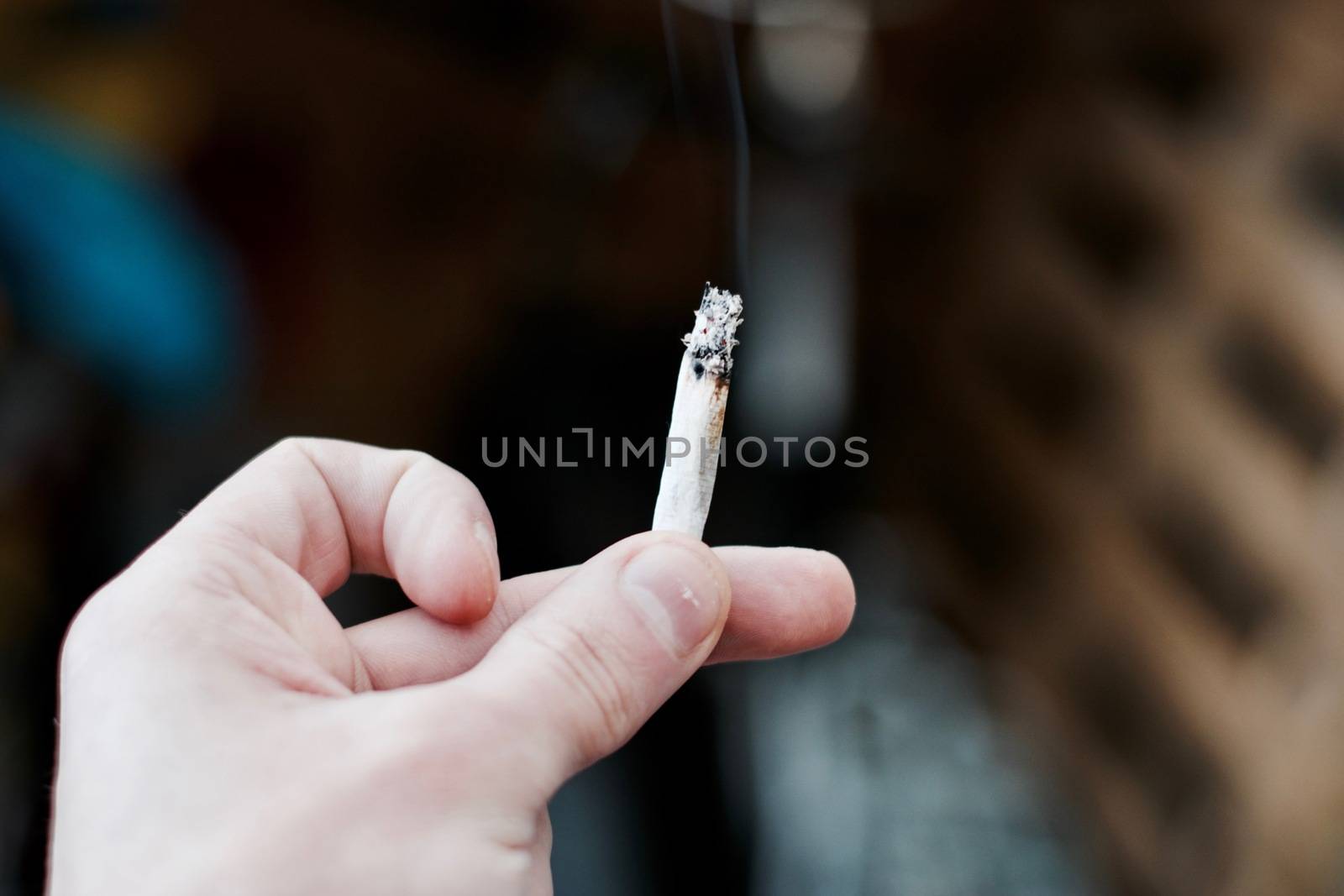 Small spliff in man hand. Marijuana smoking concept.