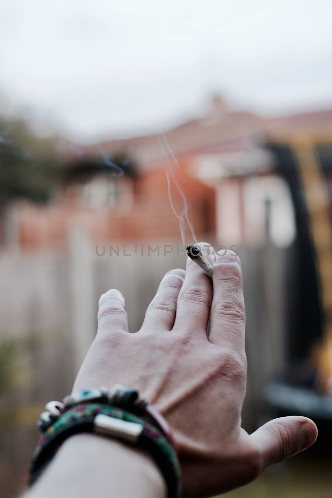 Small spliff in man hand. Marijuana smoking concept.