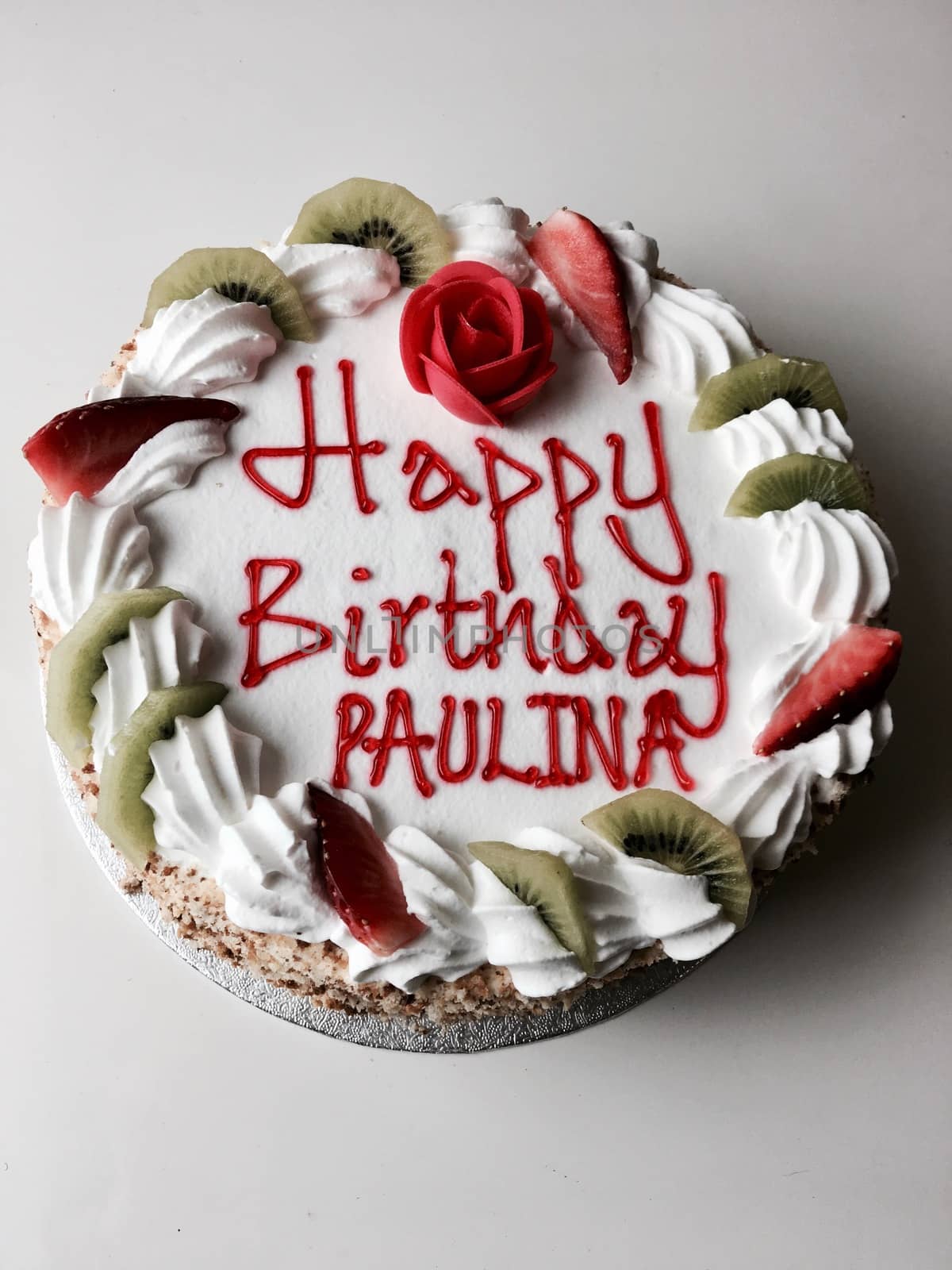 Tasty cake with happy birthday paulina inscription. Cake with strawberry and kiwi.