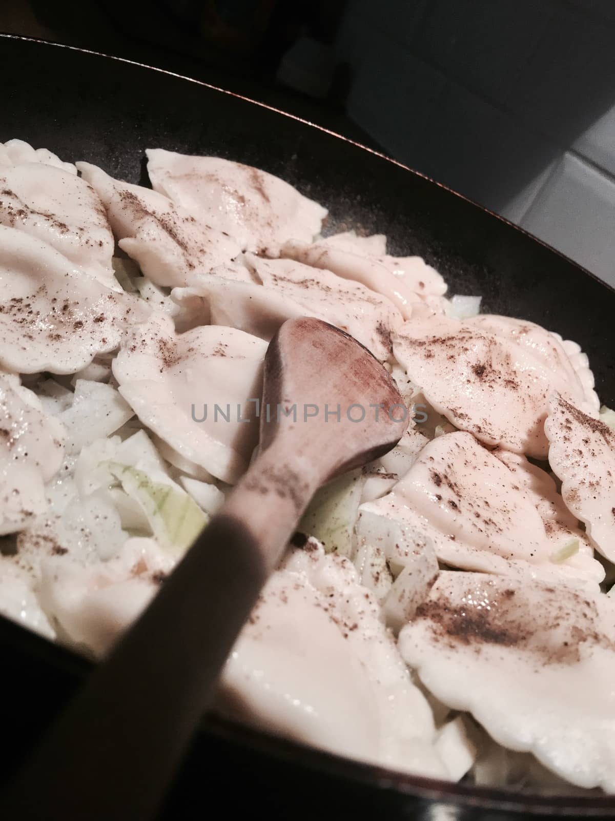 Food concept. Fresh and delicious dumplings on black pan in the kitchen