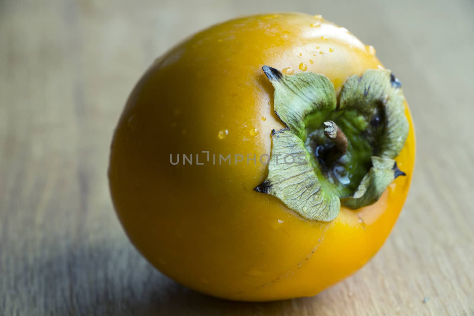 Fresh ripe orange persimmon on wooden background.