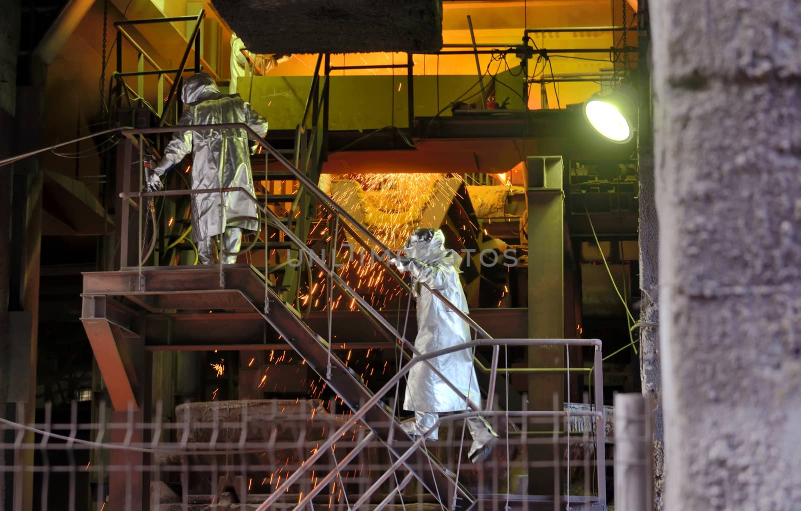 Molten Metal Pouring Out Of Furnace and Workers