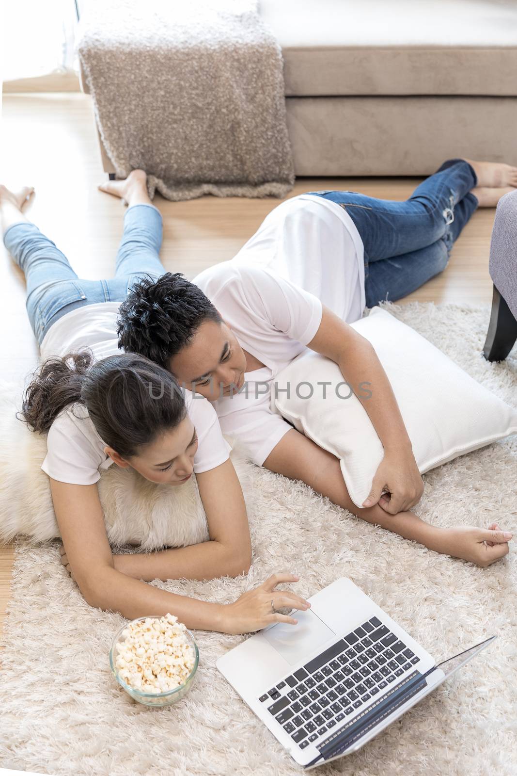 Couples lying down using laptop by vichie81