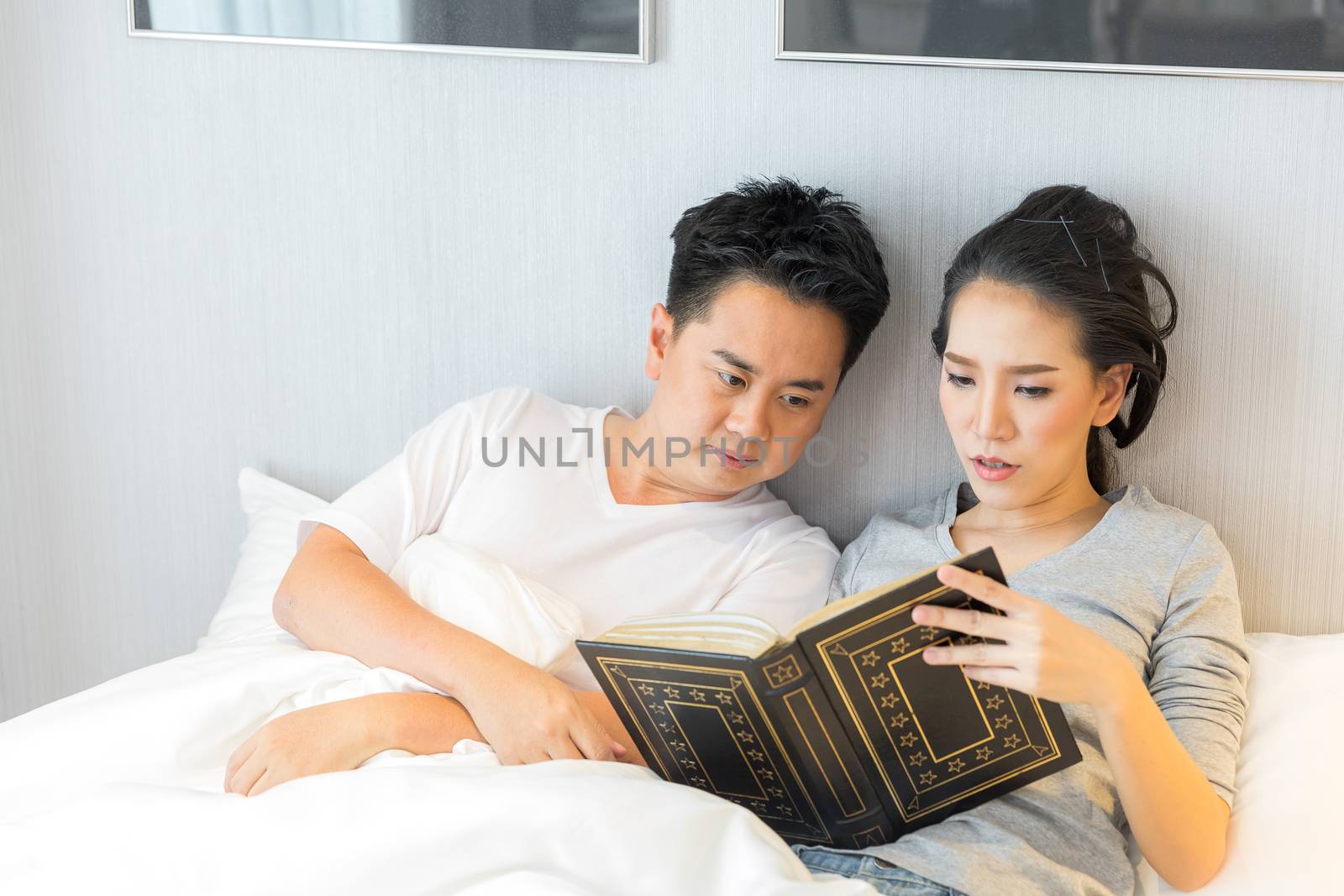 Couple reding book in bed by vichie81