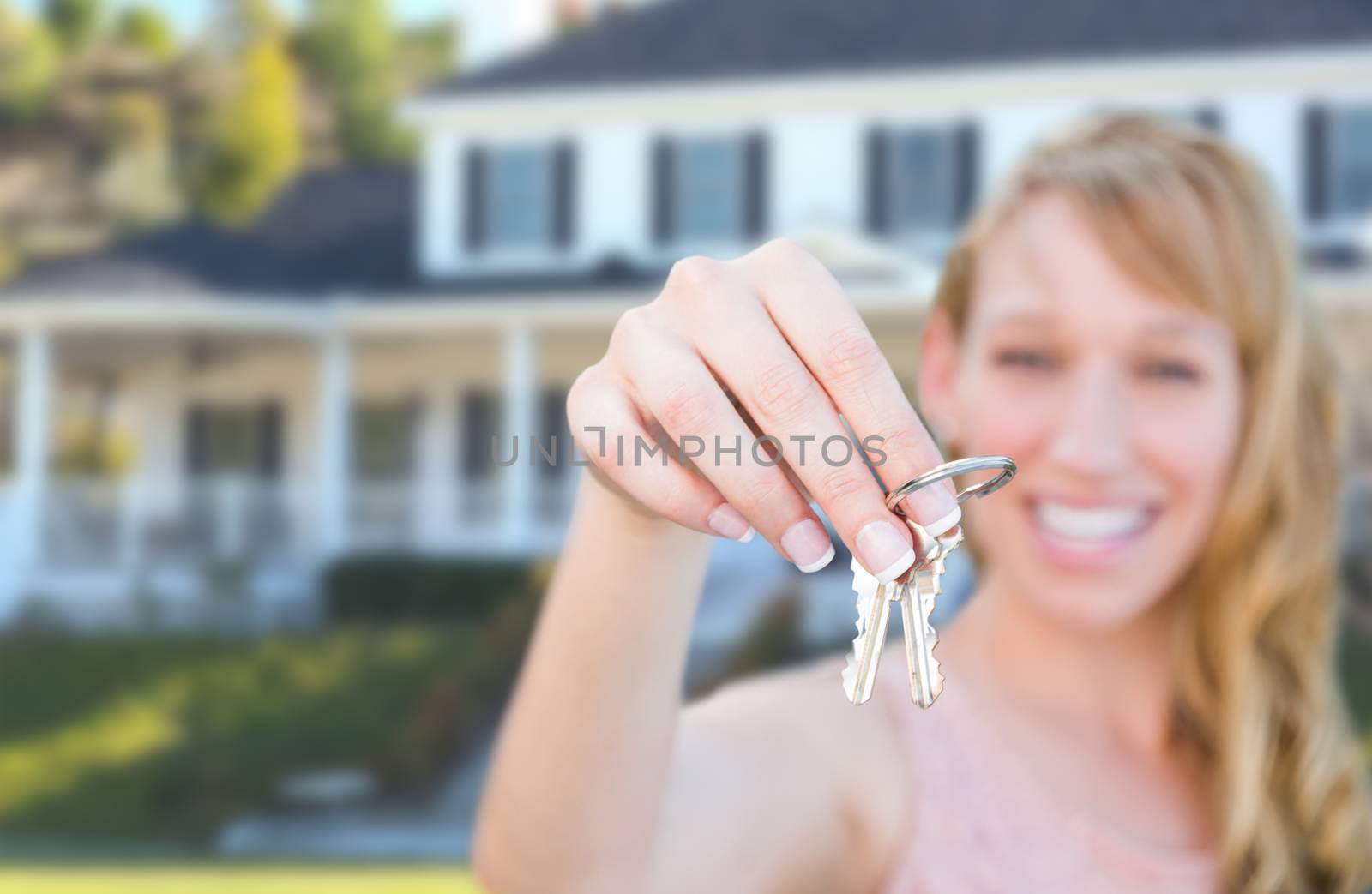 Excited Female Holding House Keys in Front of Nice New Home.