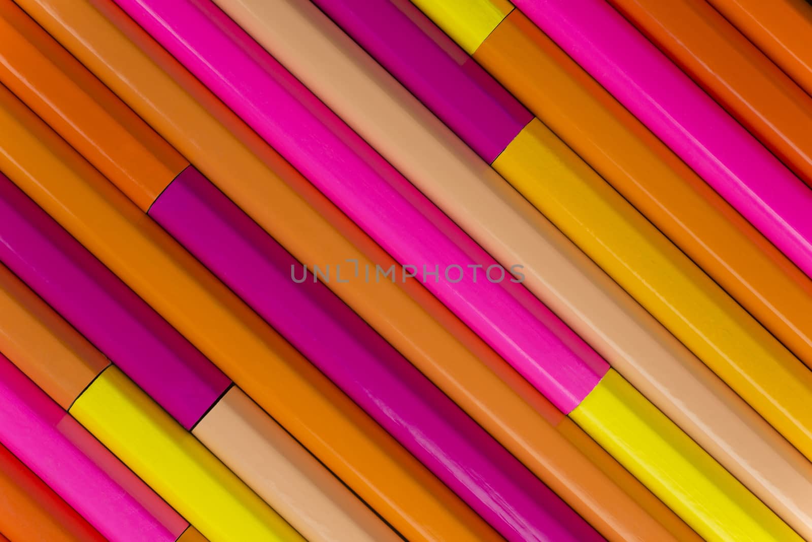 Collection of rose orange pencils in a diagonal line pattern as background picture
