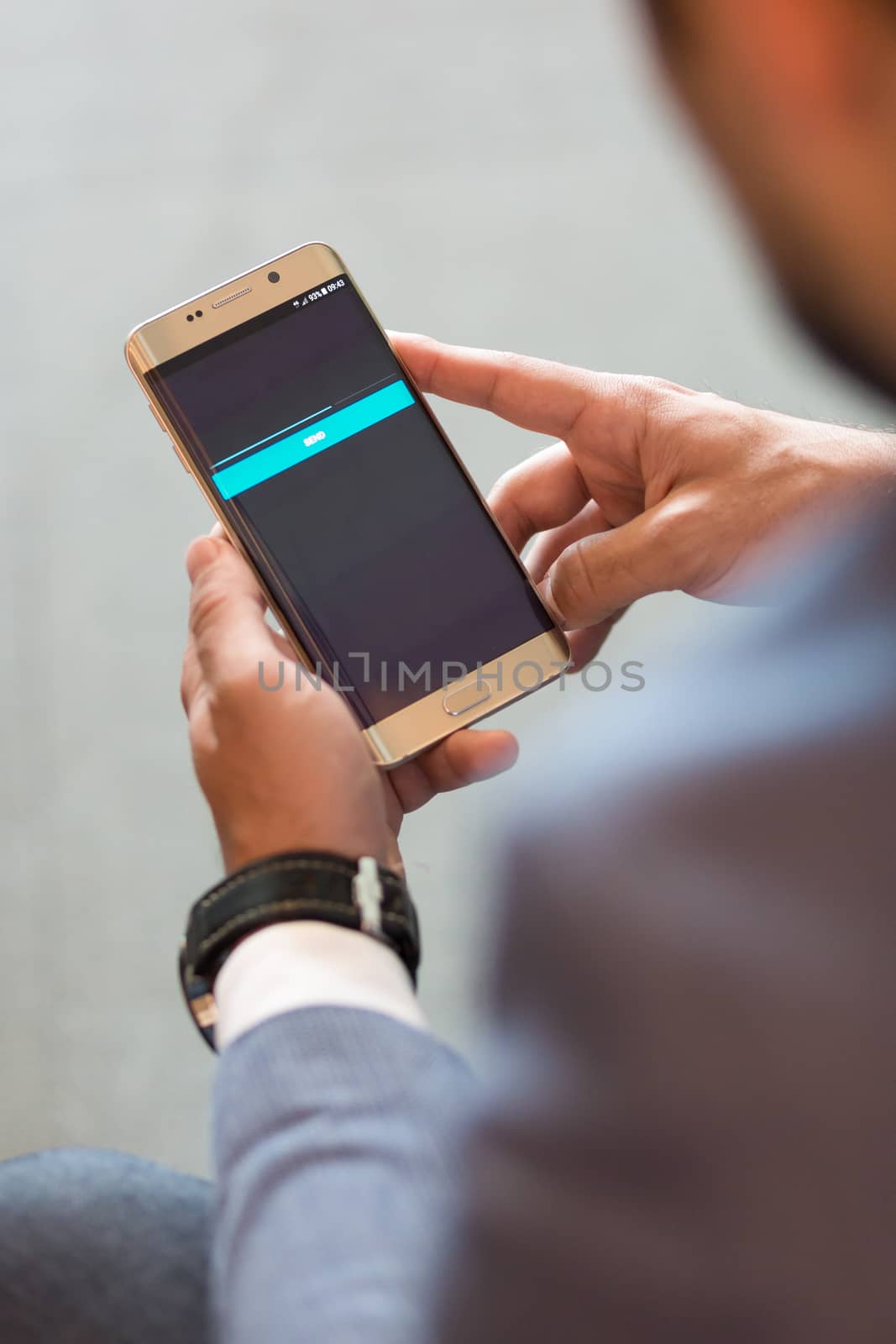 Close up of a businessman using smart phone. Focus on mobile device.