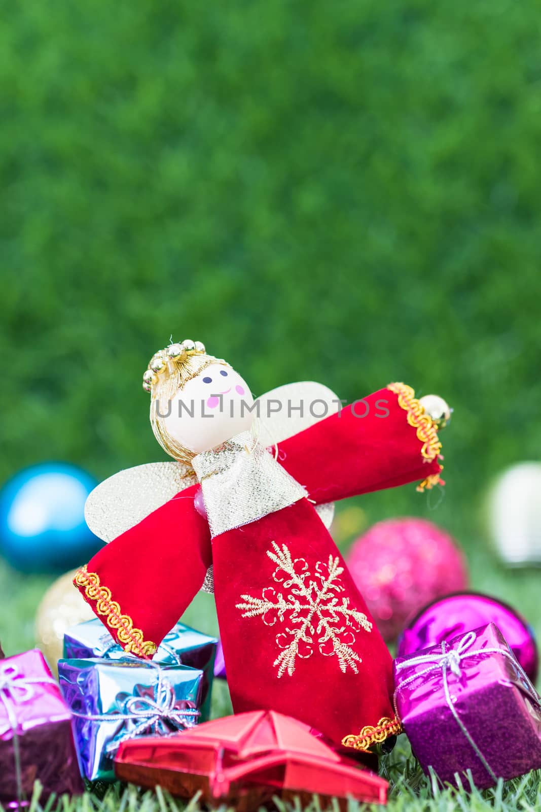 Celebration of New year and Christmas, Christmas angel doll and christmas decoration on green grass background