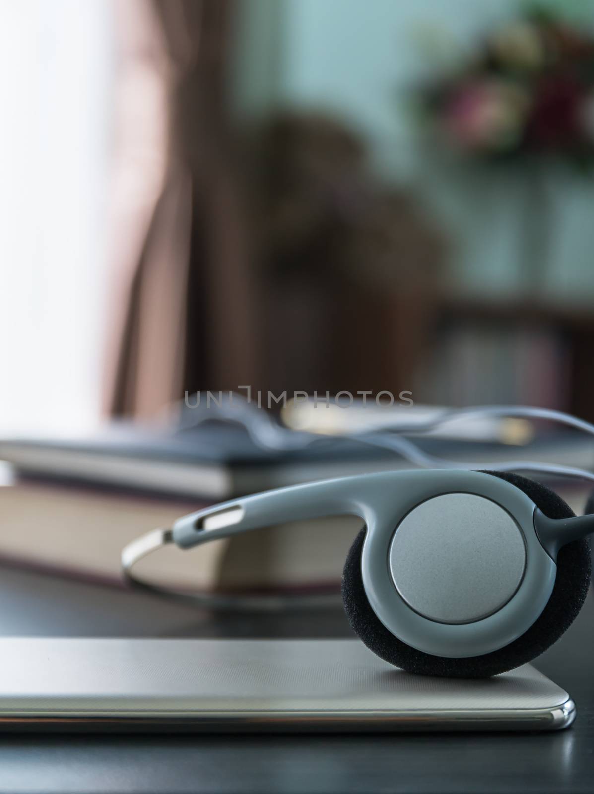 Headphones with book and mobile phone on wood table