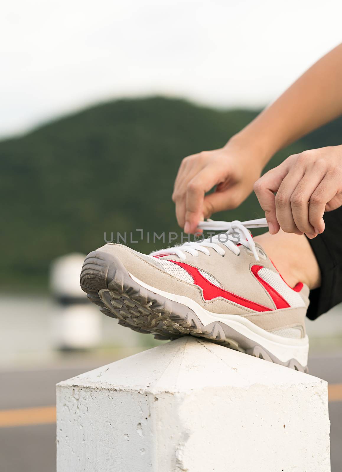 Woman runner tying shoelace his before starting running, Woman doing exercises and warm up before run daily routine workout