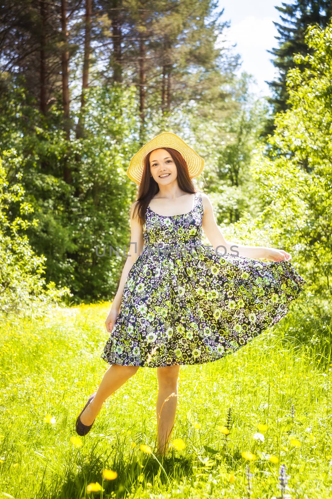 beautiful young brunette woman on the meadow on a warm summer day