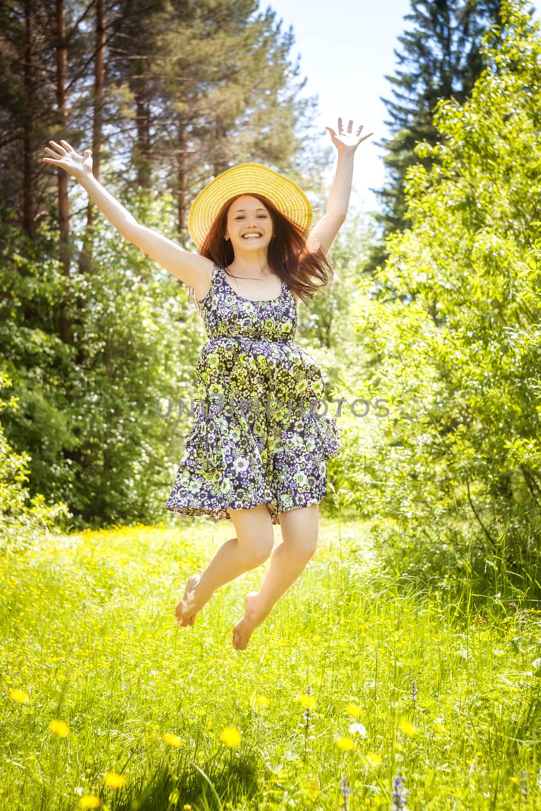 beautiful young brunette woman on the meadow on a warm summer day