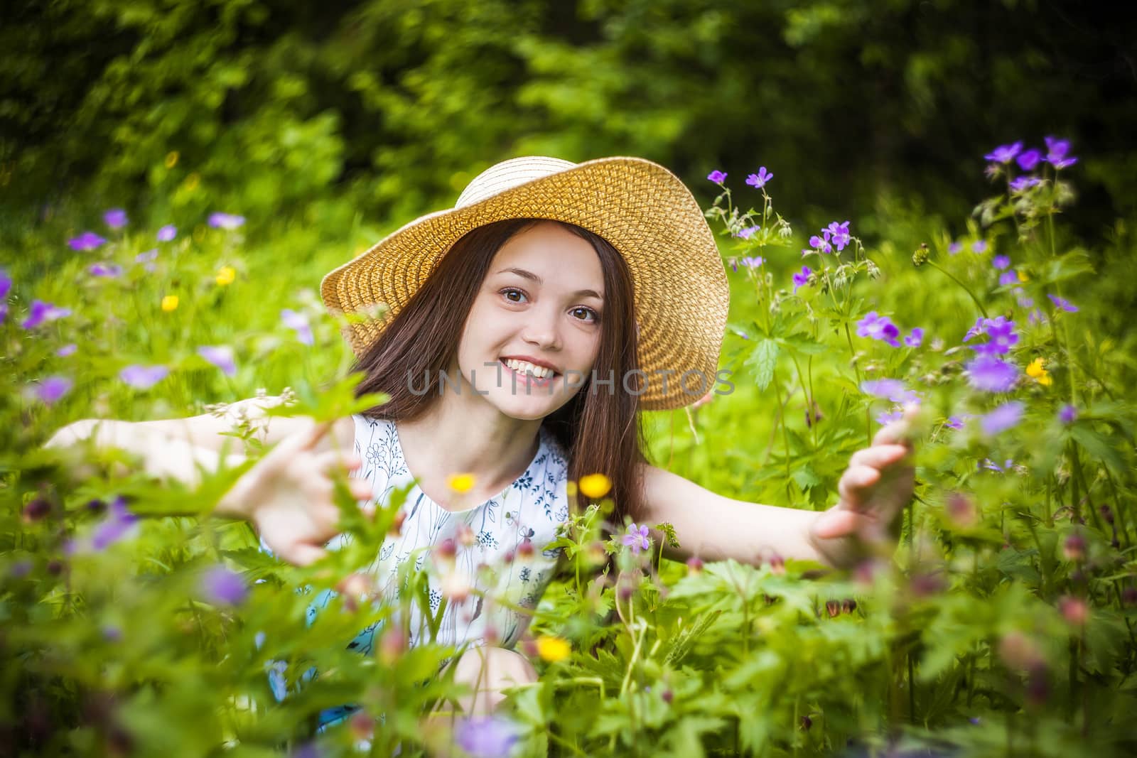 beautiful young brunette woman on the meadow on a warm summer day