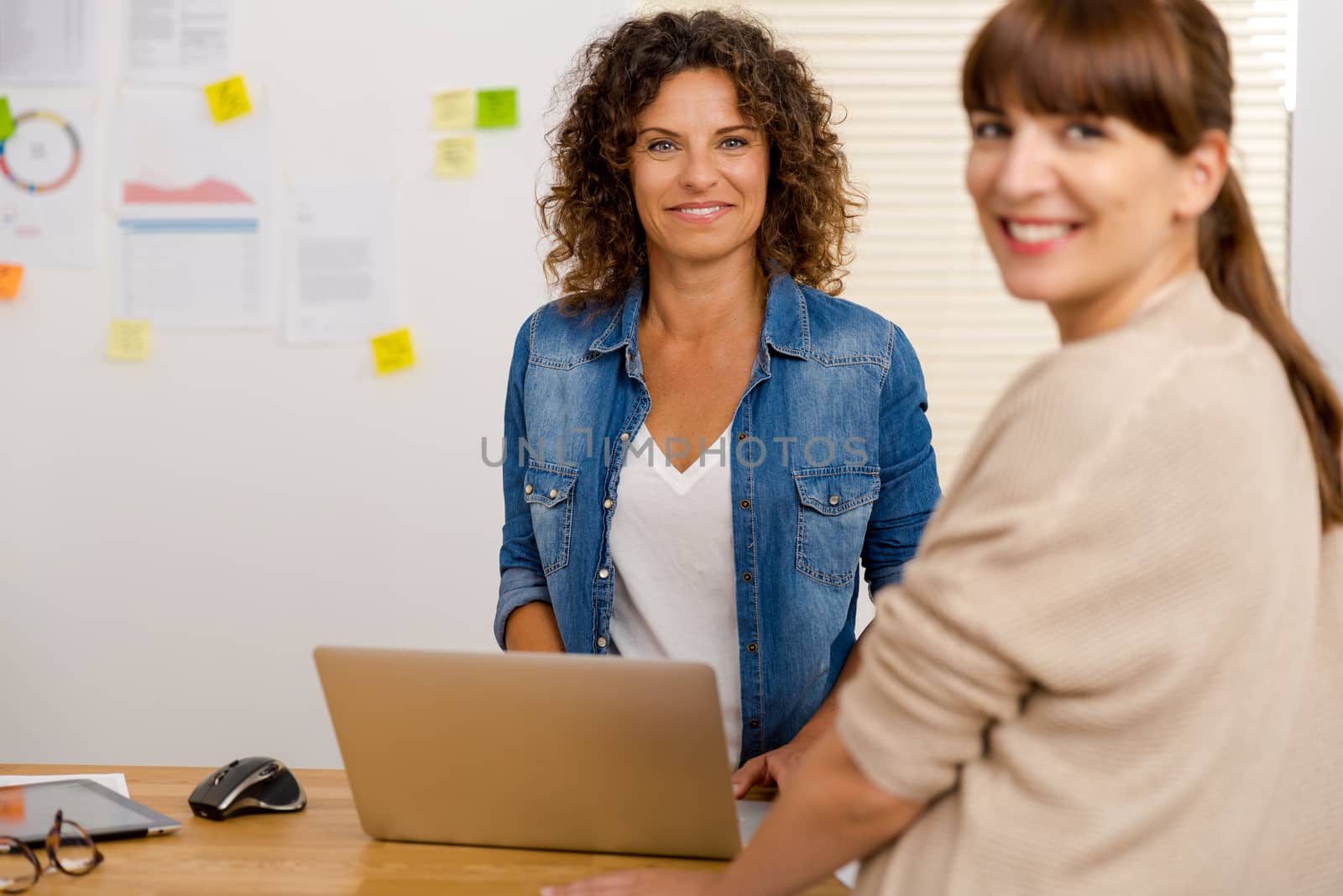 Two happy businesswoman working together in an office