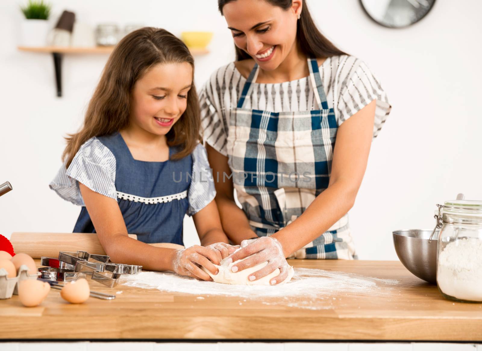 Shot of a mother and daughter having fun in the kitchen and learning to make a cake