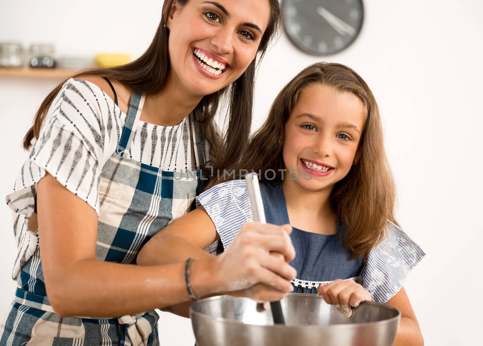 Shot of a mother and daughter having fun in the kitchen and learning to make a cake