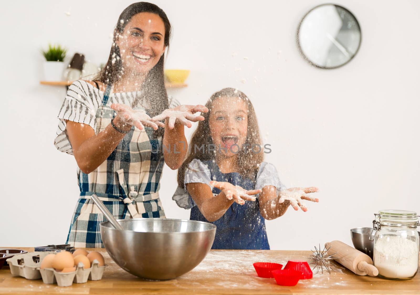 Shot of a mother and daughter having fun in the kitchen and learning to make a cake