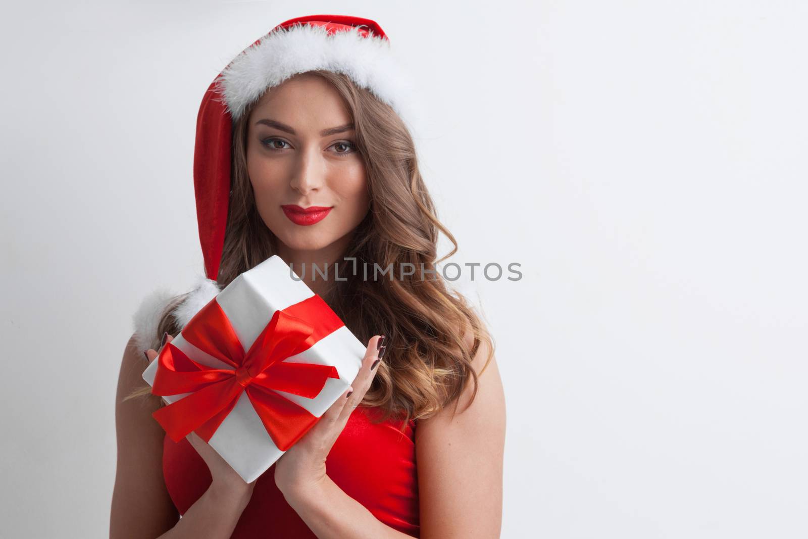 Beautiful woman in Santa Claus style dress with gift box