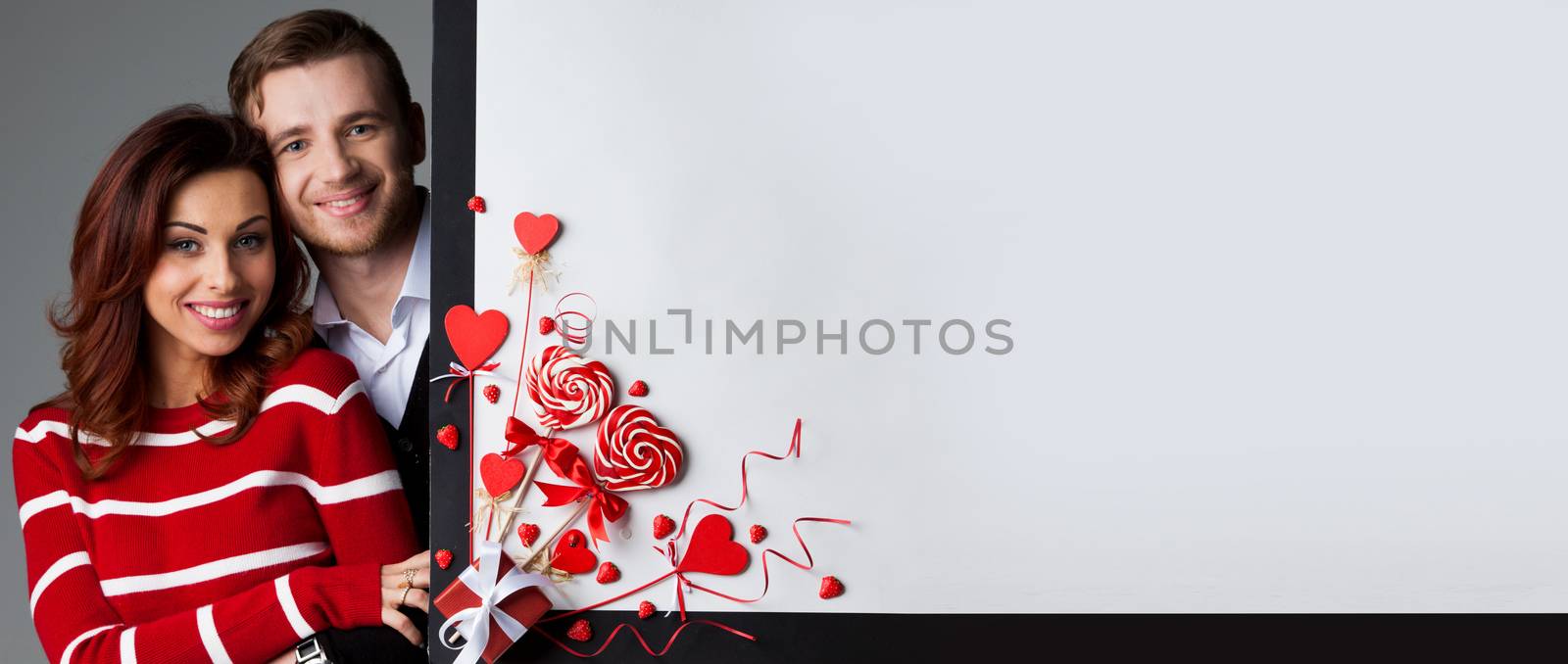 Happy couple posing with Valentine's day decoration with white copy space