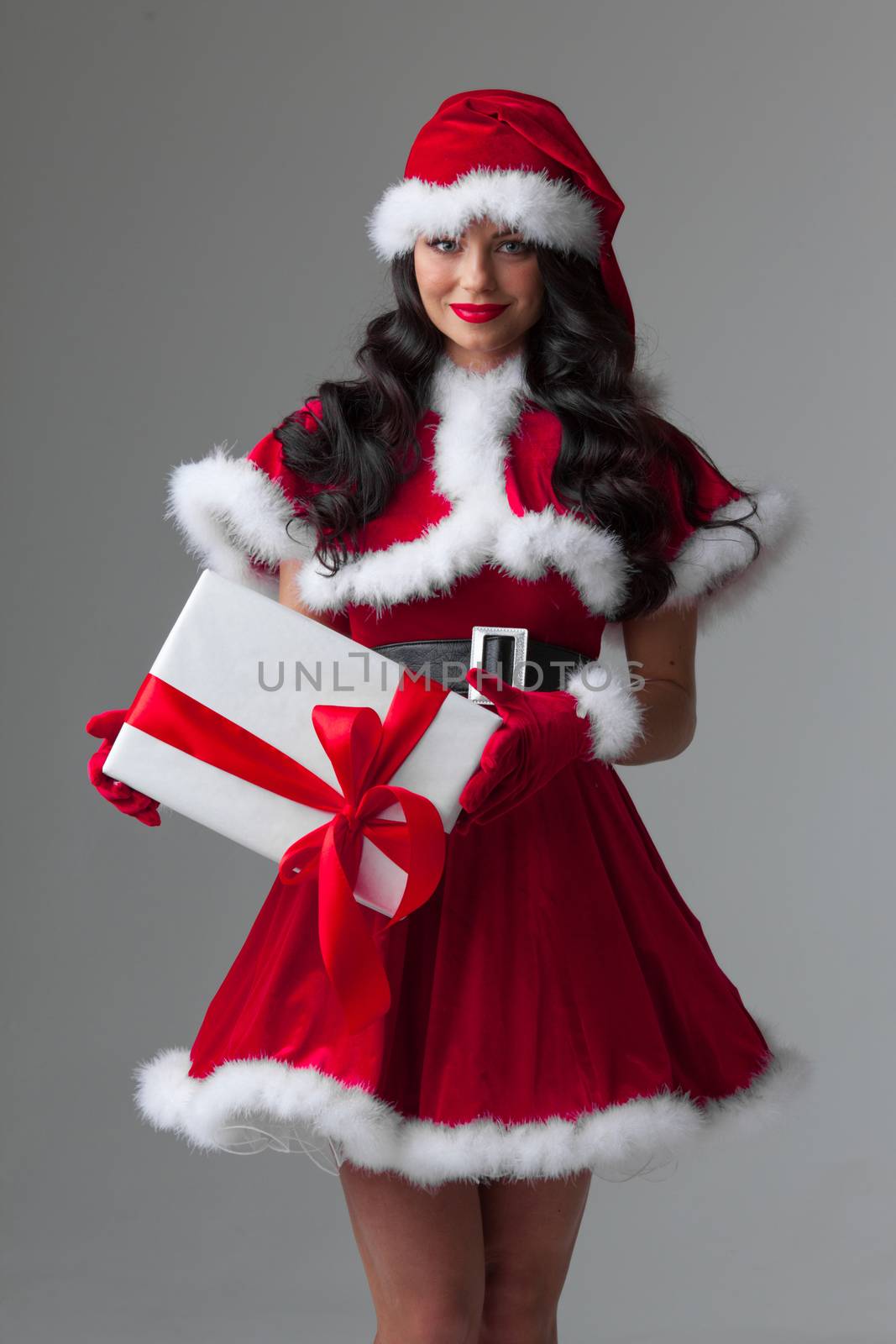 Beautiful woman in Santa Claus style dress with gift box