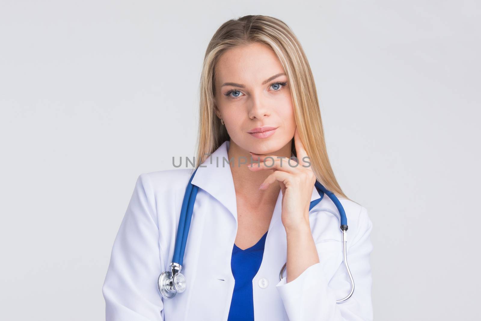Close-up portrait of a beautiful thoughtful female doctor on gray background