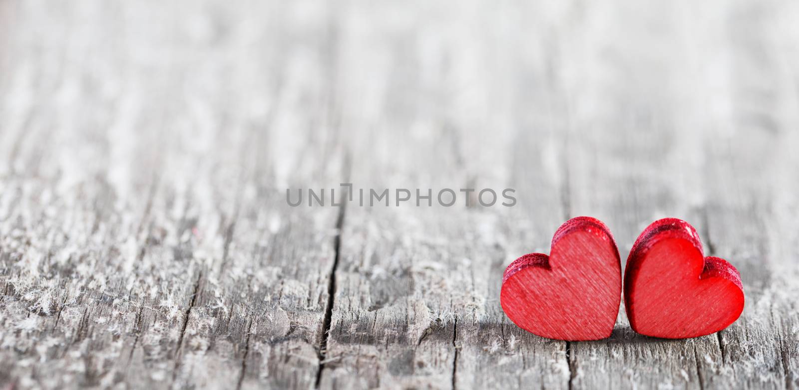 Two small hearts on old wood background