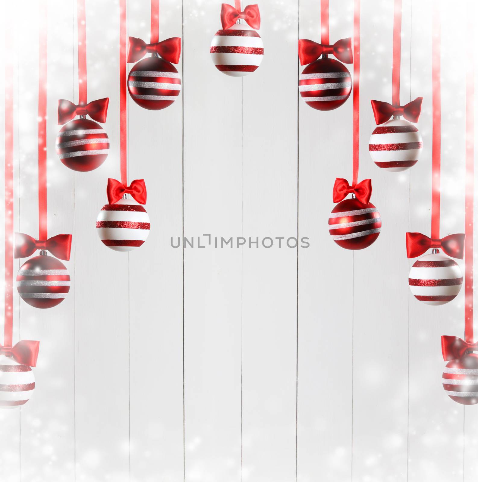 Red Christmas balls hanging on red ribbons on white background