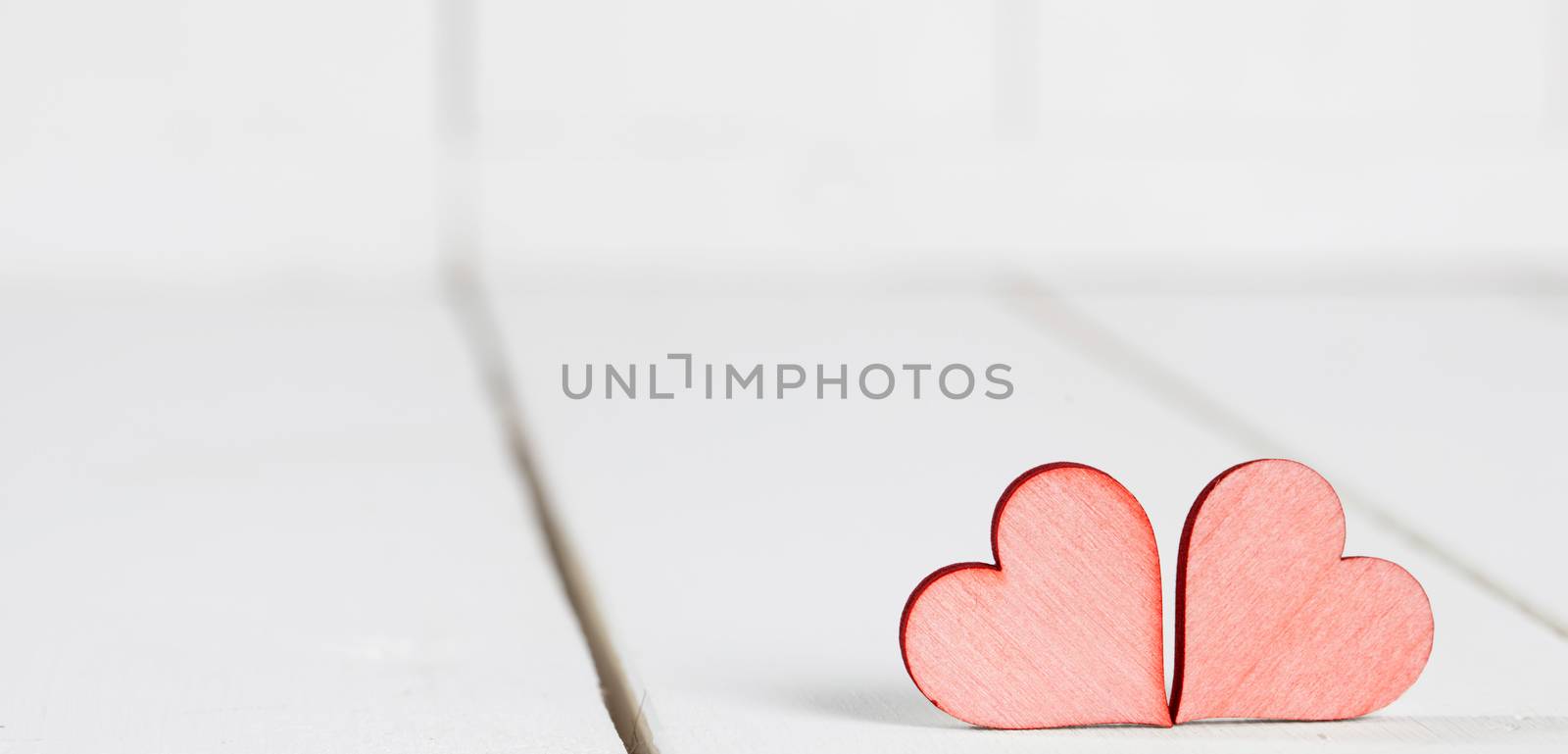 Two small hearts on old wood background