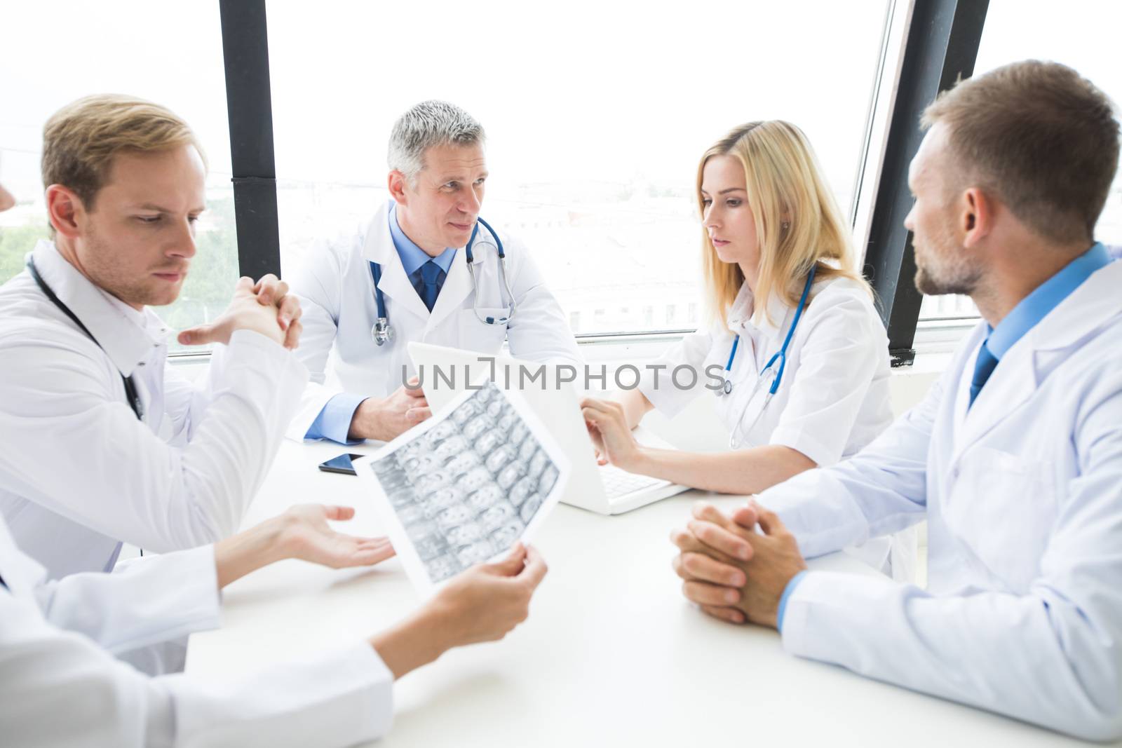 Clinic, people, healthcare and medicine concept - group of medics with brain x-ray scan at hospital