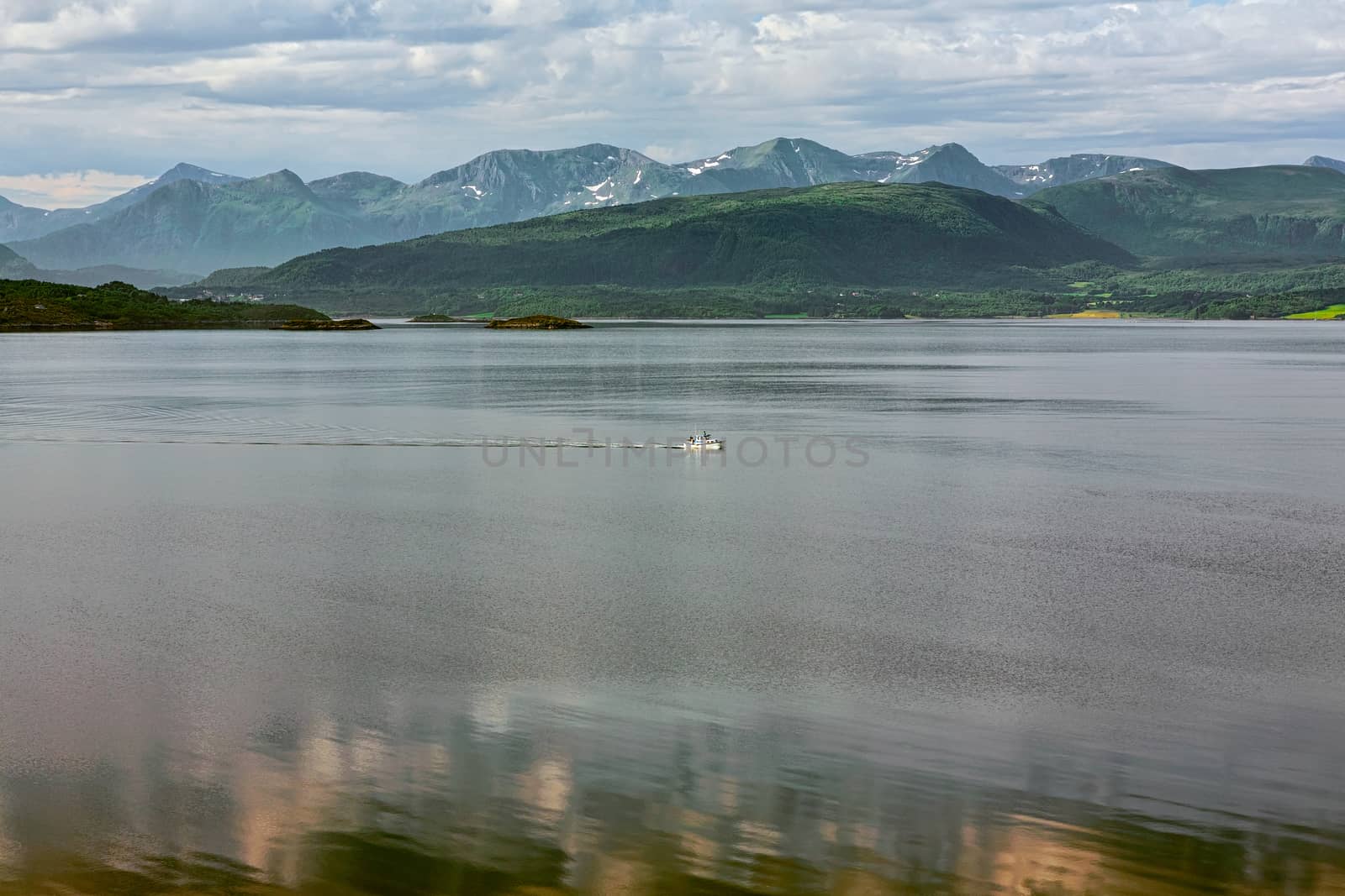 Panoramic mountain view with a boat sailing in the fjord in Molde, Norway