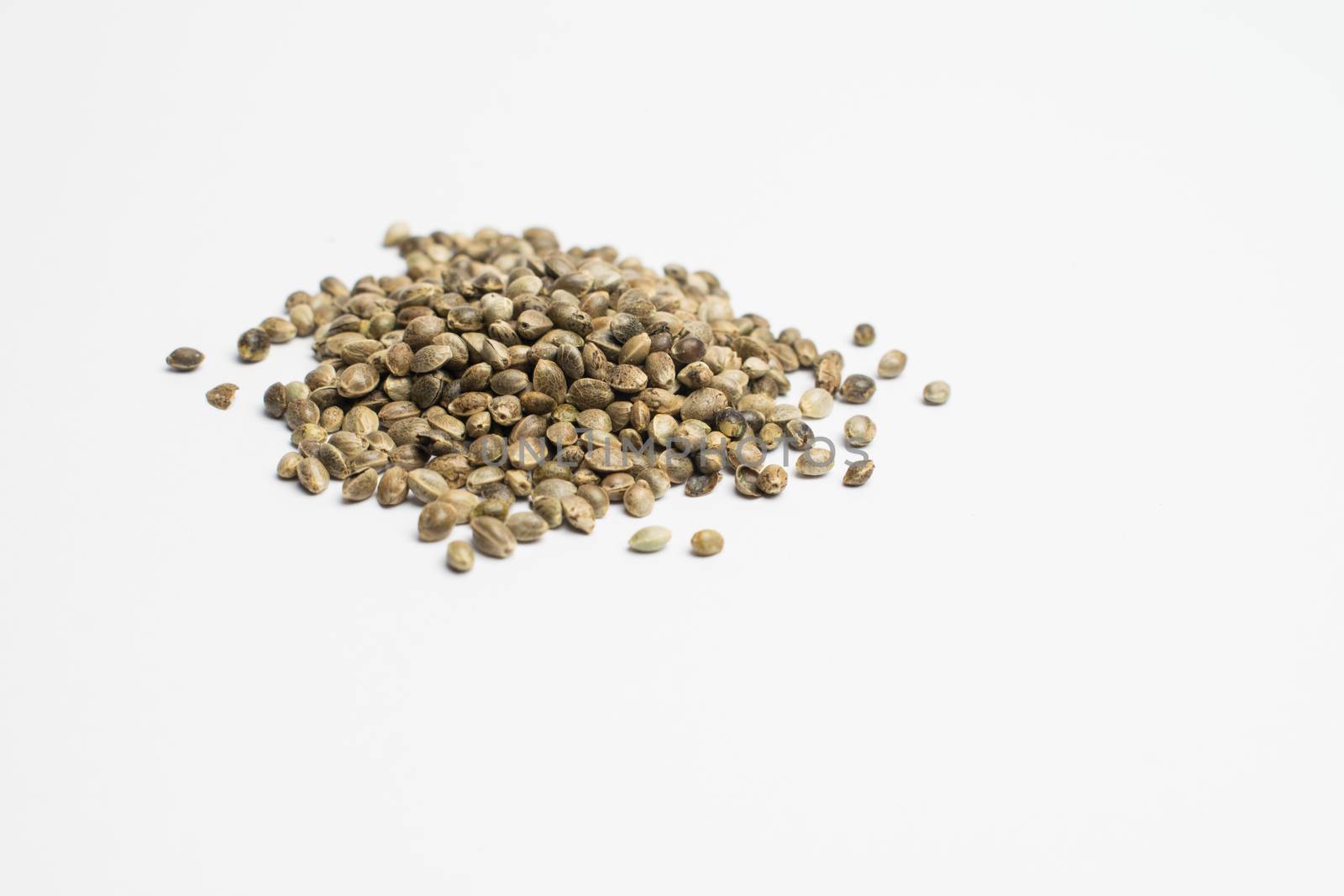 A group of raw cannabis seed disposed on a white background