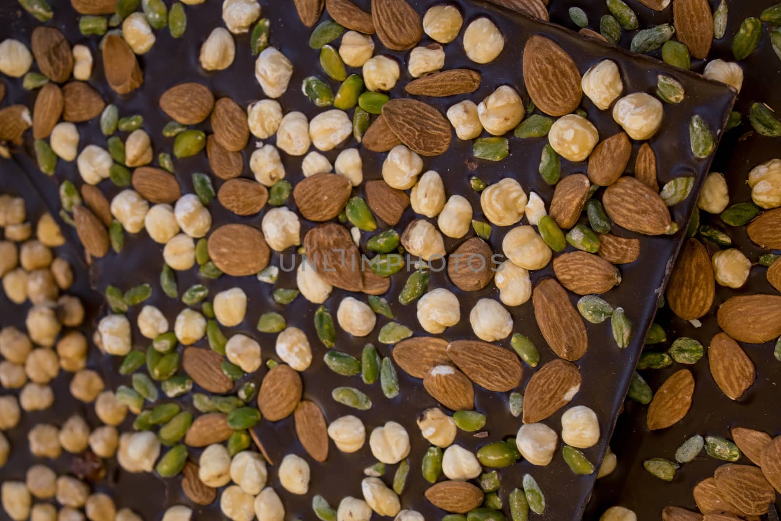 Some pieces of brown chocolate with almons, nuts and pistachio