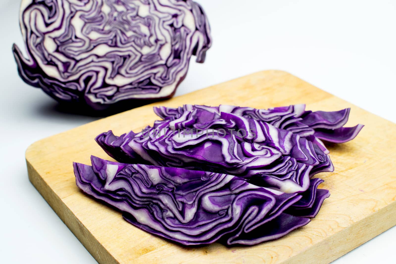 A portion of a red cabbage disposed on a white background