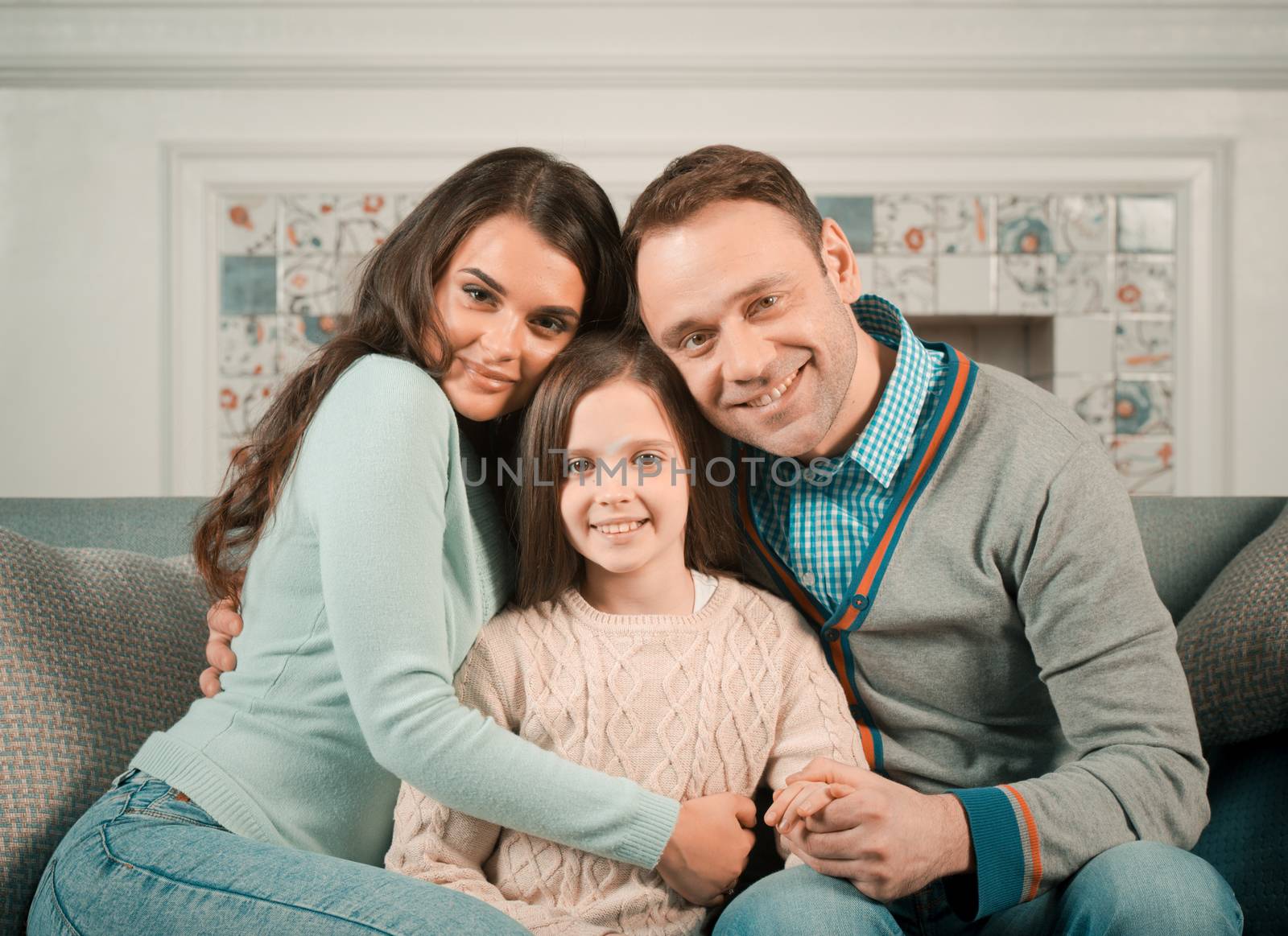 Family portrait of happy parents and their daughter at home