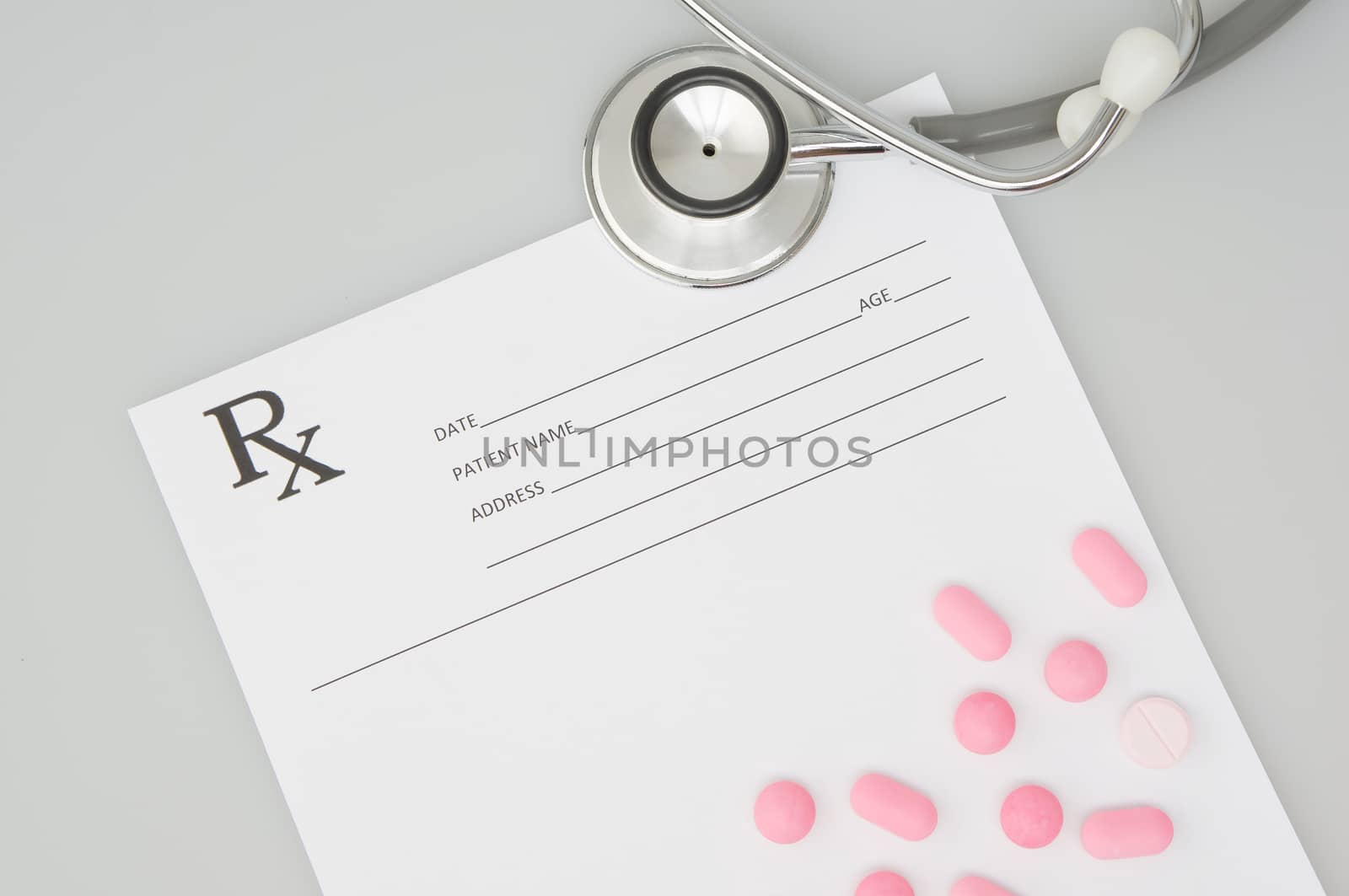 Old silver medical stethoscope and pink pills on rx prescription by eaglesky