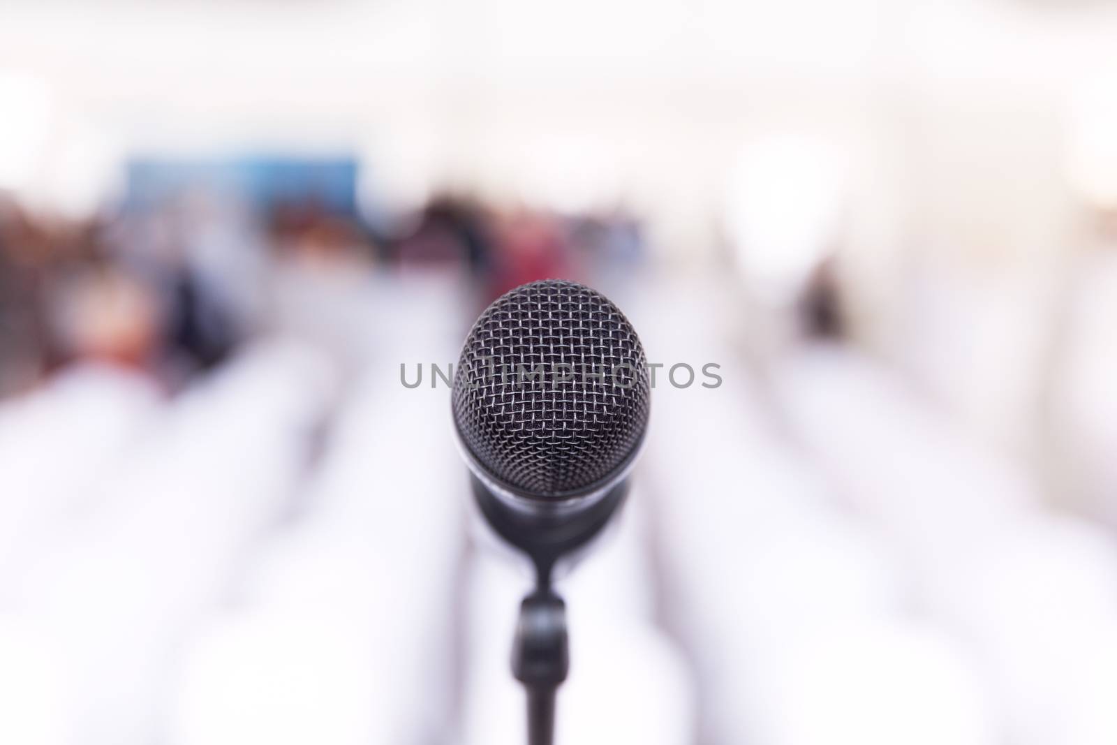 Microphone in focus, conference hall without auditorium in the b by wellphoto