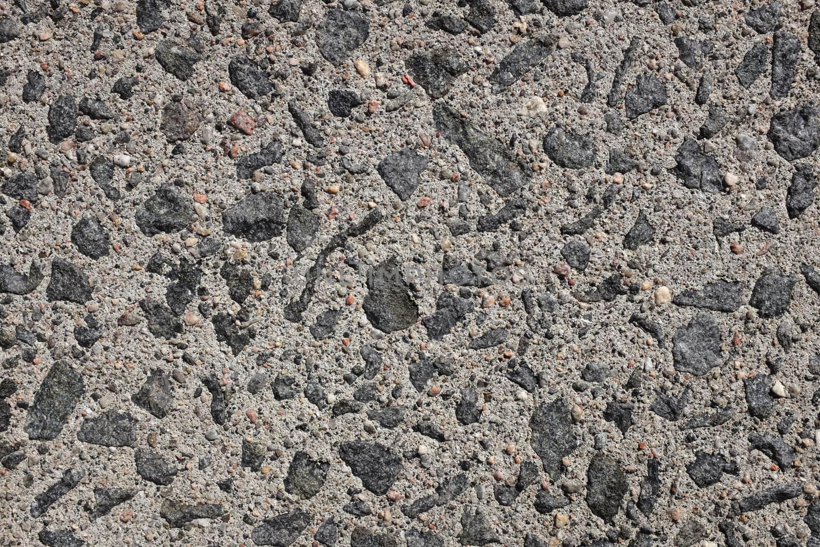 Exposed aggregate concrete paving, with small stones and grit as abstract background texture