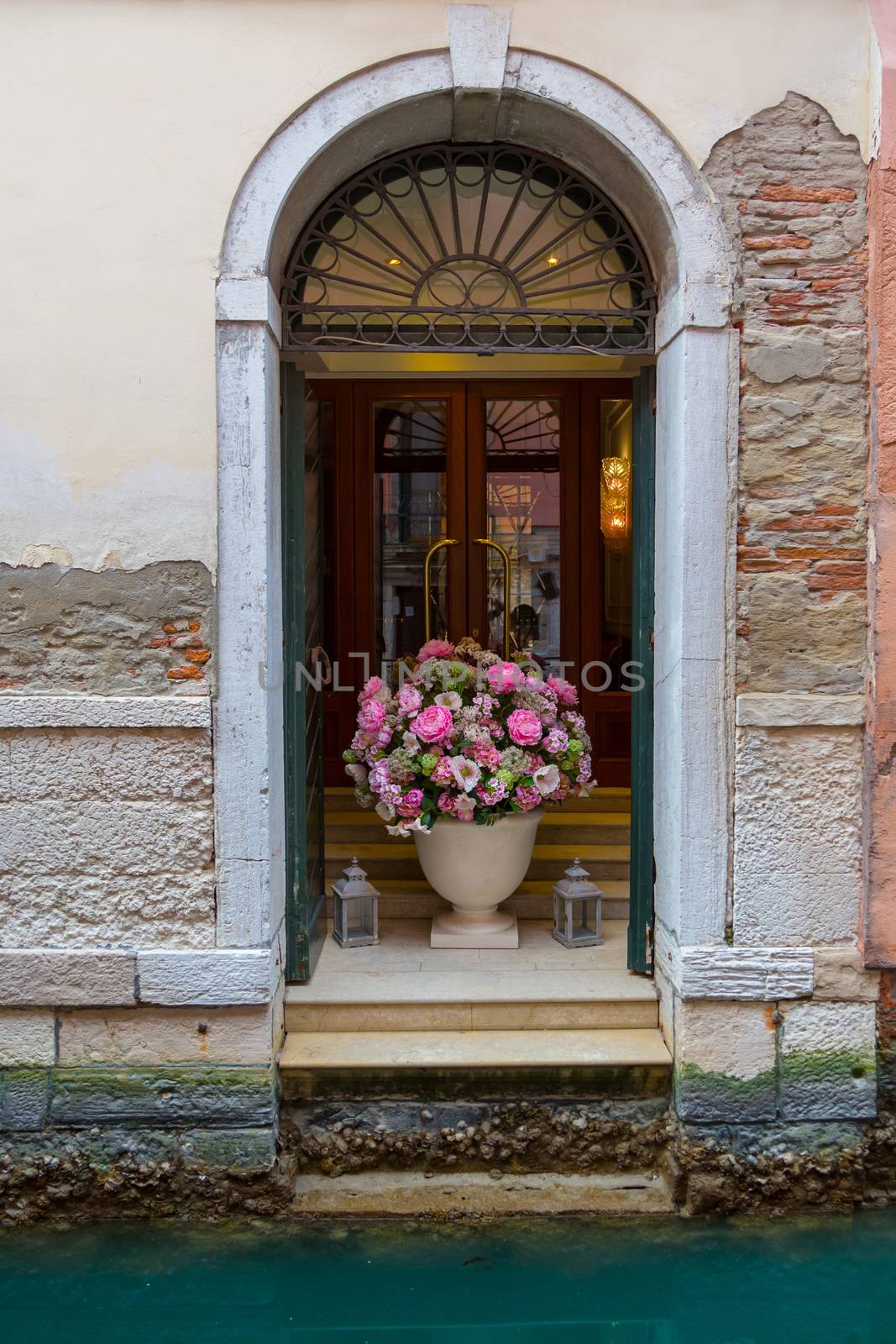 Entrance to the hotel in Venice goes to the canal. Entry of a Venice house in Italy with the water of the canal up to the entrance. Venice canal.