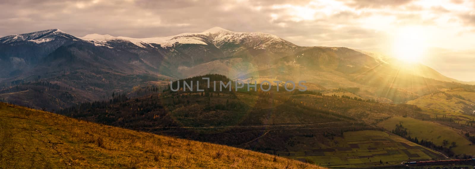 great mountain ridge Borzhava with snowy tops at sunset. beautiful countryside landscape in late autumn
