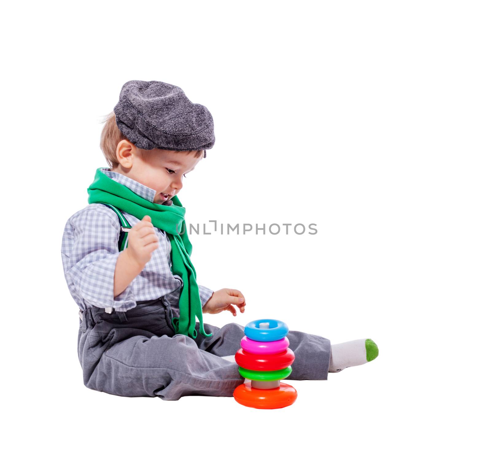 Toddler boy playing with colorful pyramid toy isolated on white